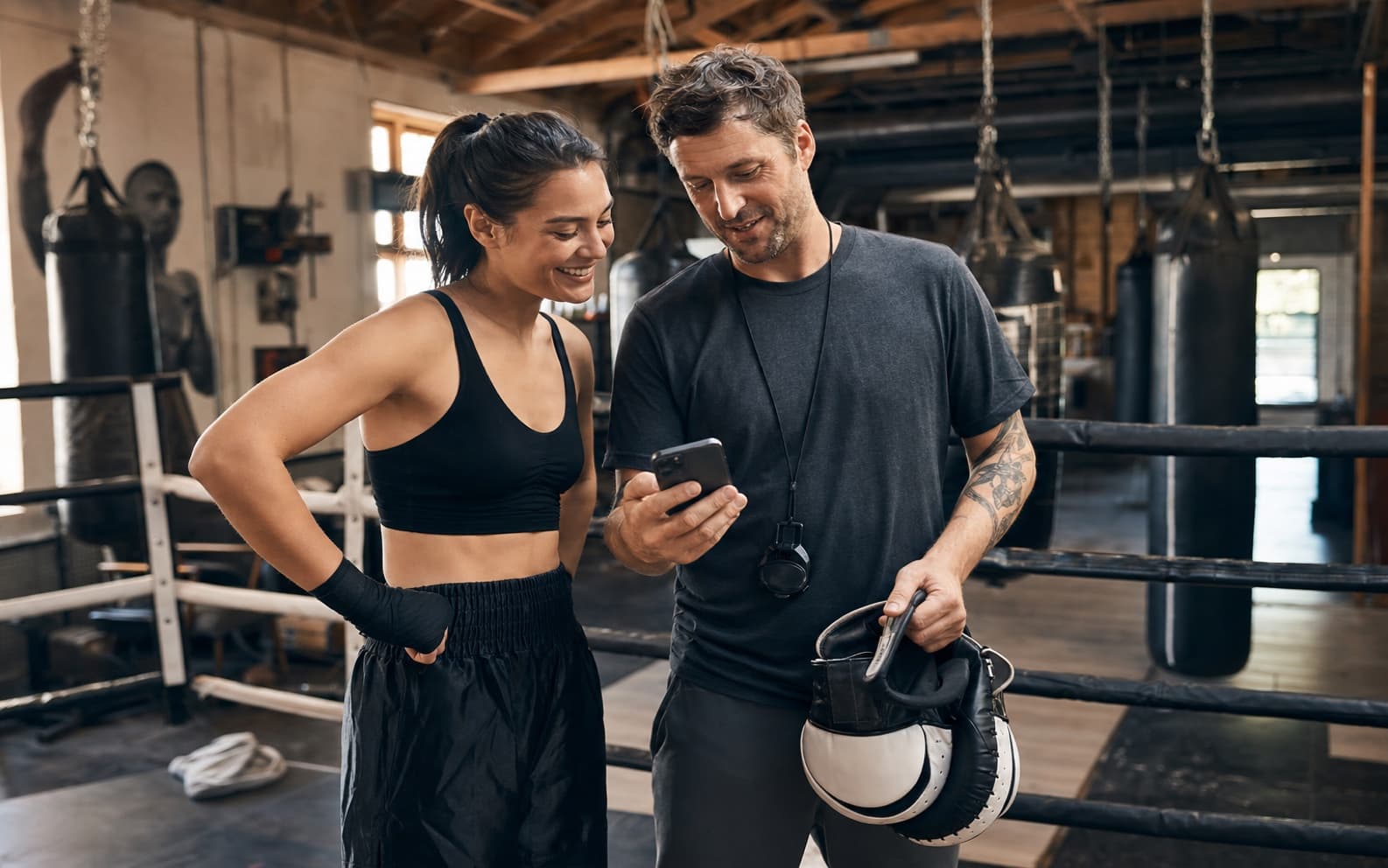Boxing coach and athlete checking the pack balance after training